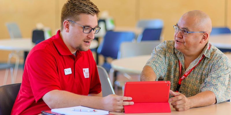 Red Cross Instructor with laptop instructing on resources