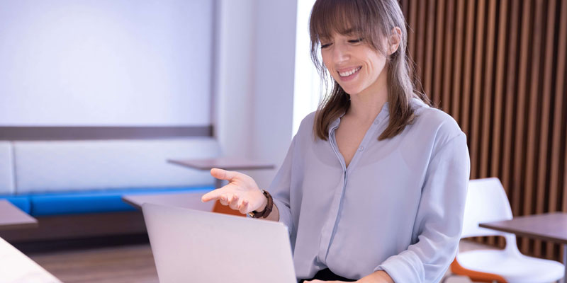 Woman Standing with laptop in classroom